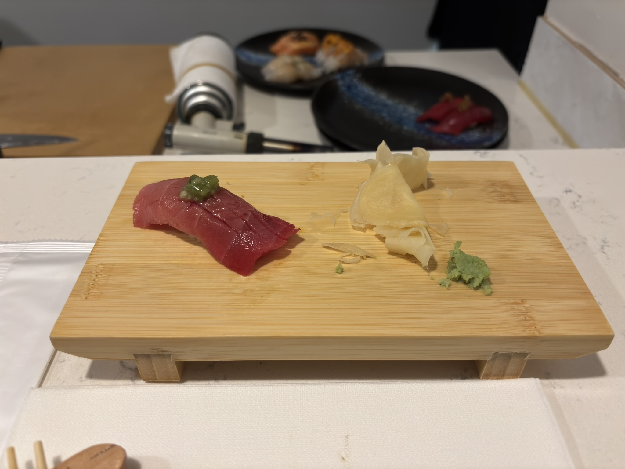 Tuna nigiri with a green garnish at Shinzo Omakase