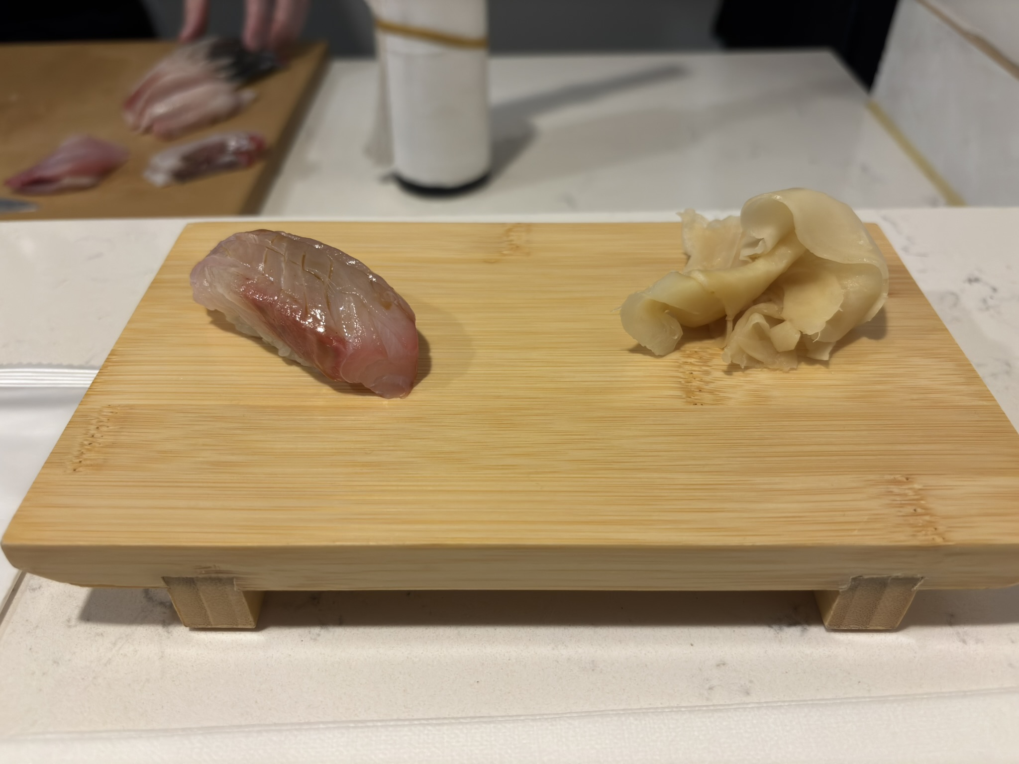 White fish nigiri served on a bamboo board at Shinzo Omakase