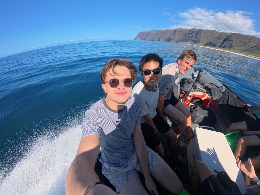 Friends speeding along the Nā Pali Coast by boat