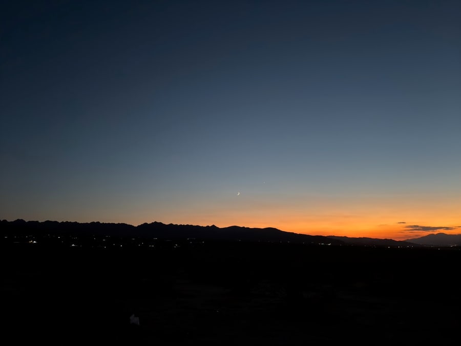 Orange sunset behind a dark desert ridgeline