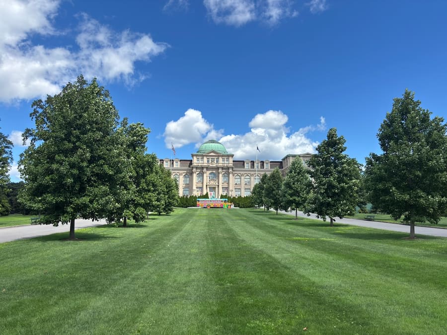 Library building beyond a broad tree-lined lawn