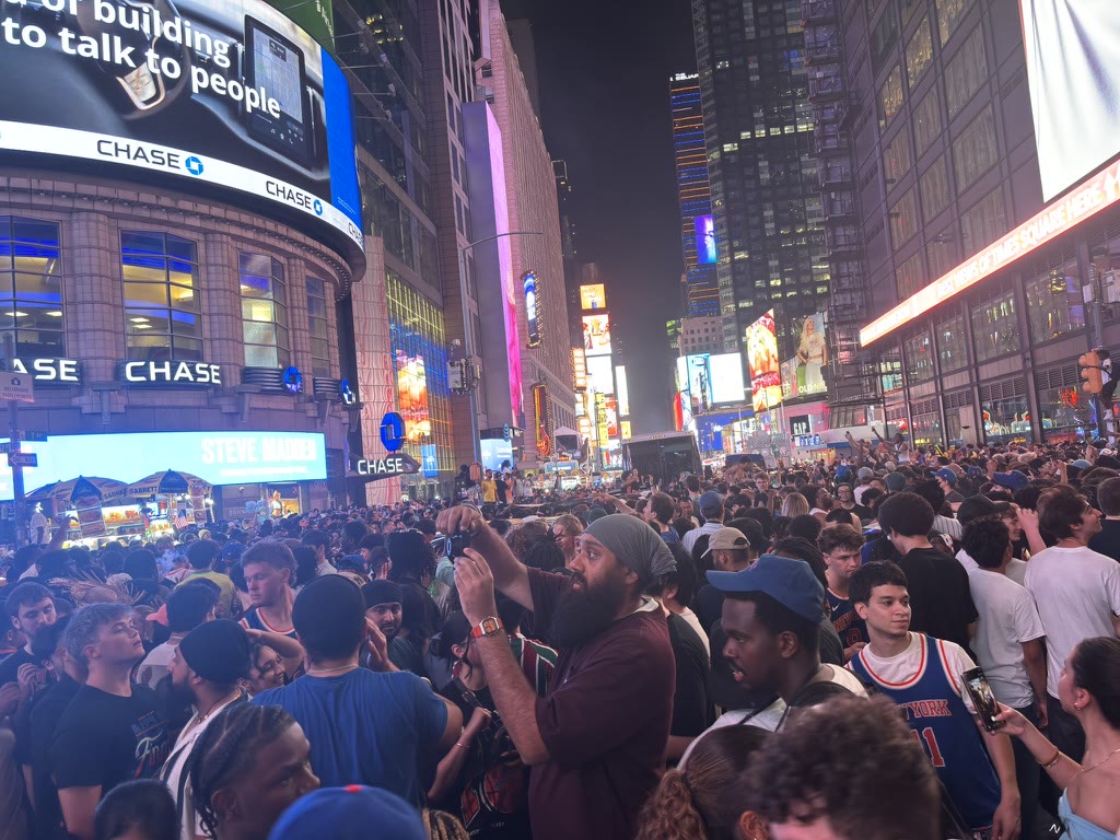 Crowd of Knicks fans filling a brightly lit Times Square