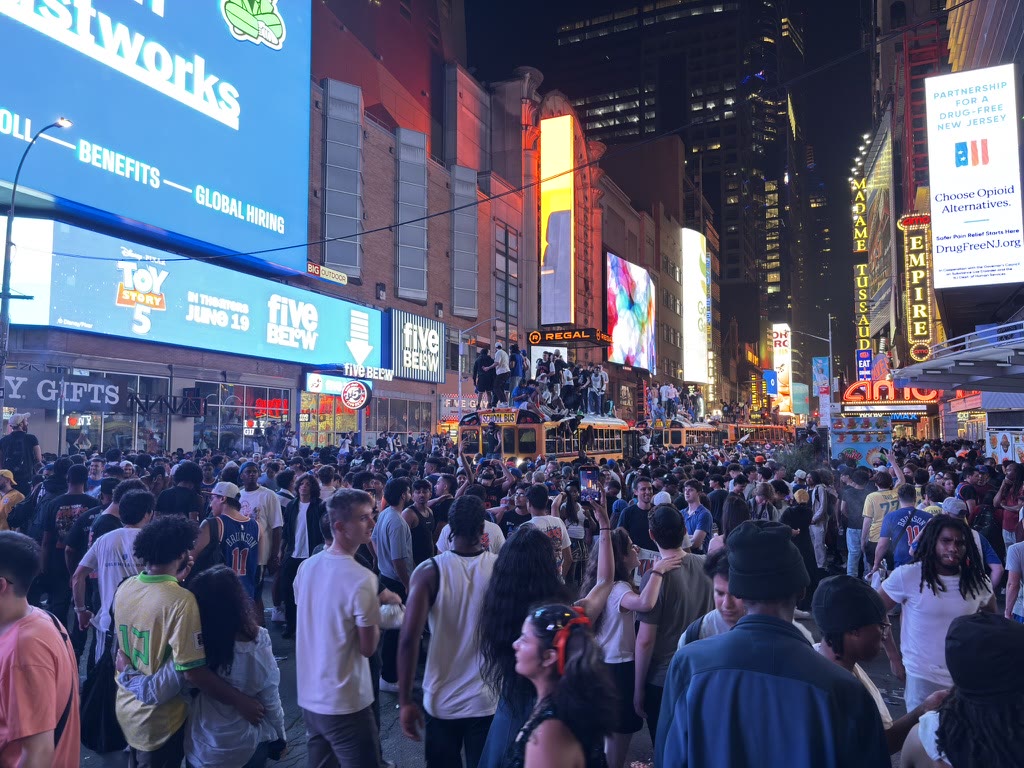 Knicks fans gathered around buses under the billboards of Times Square