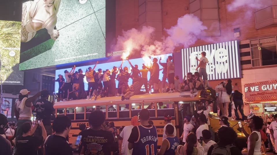Knicks fans celebrating beneath smoke and city lights