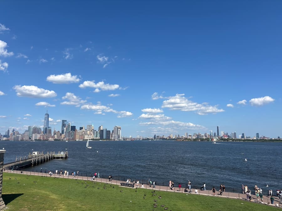 Lower Manhattan skyline, sailboat, and Liberty Island waterfront