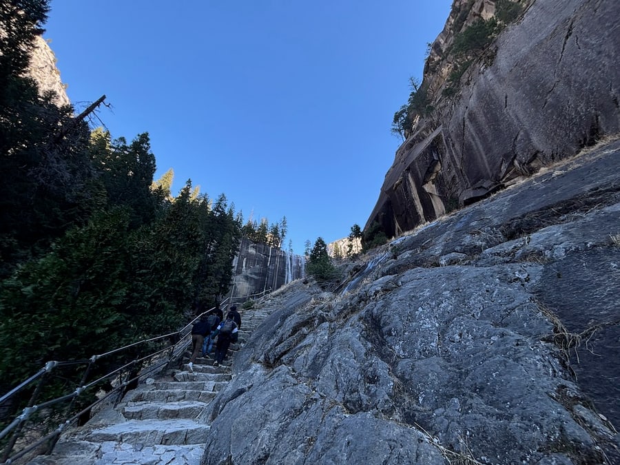 Hikers approaching a frozen waterfall on a snowy trail
